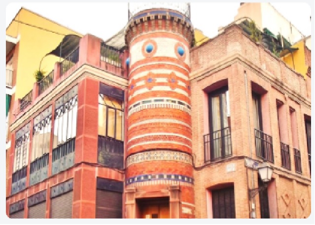 Fachada de ladrillo única de un edificio histórico en Madrid que presenta una torre redondeada con d
