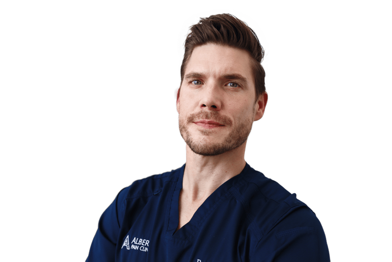 Professional portrait of a male specialist from Albert Pain Clinic wearing blue medical scrubs.