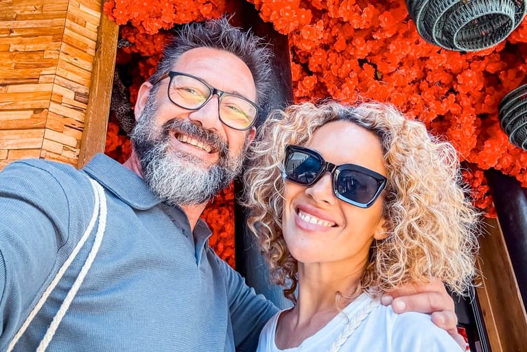 a sugar daddy and sugar baby standing in front of a red flowered wall