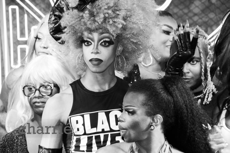 drag queen wearing shirt that says black lives matter looking out surrounded by performers