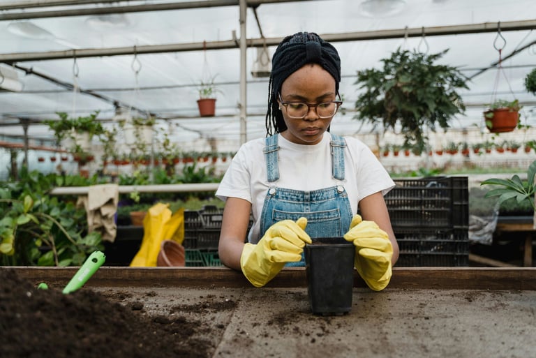 Black girl at potting table in a greenhouse. 