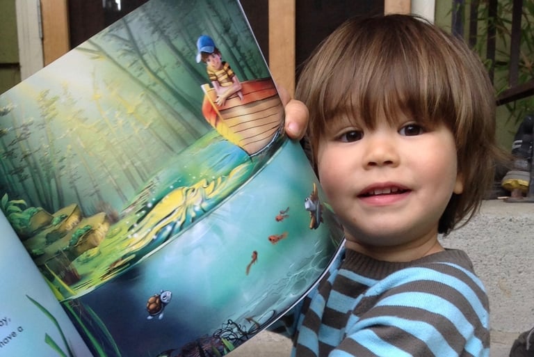 a young boy is holding a book in his hands