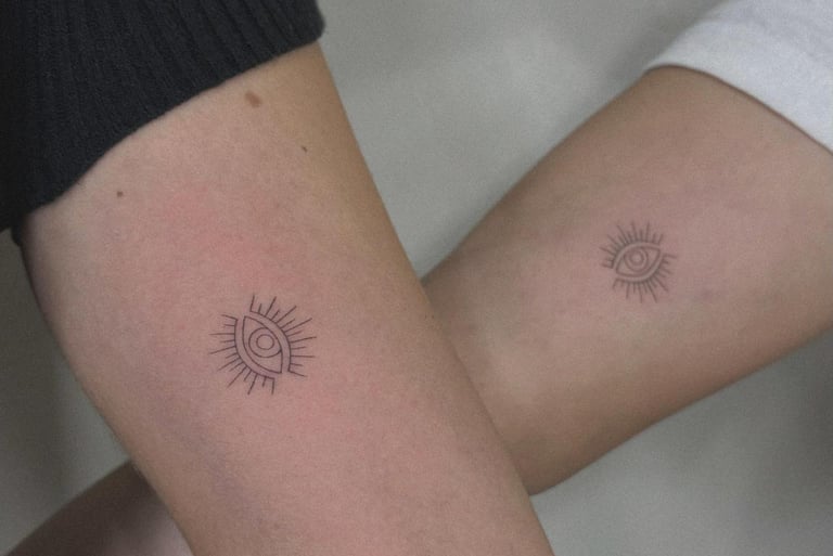 Fine line evil eye sun tattoo on upper arm – Sinkply Zürich