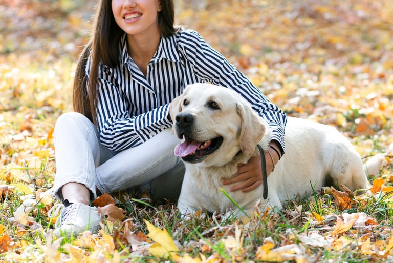 a woman sitting on the ground with her dog