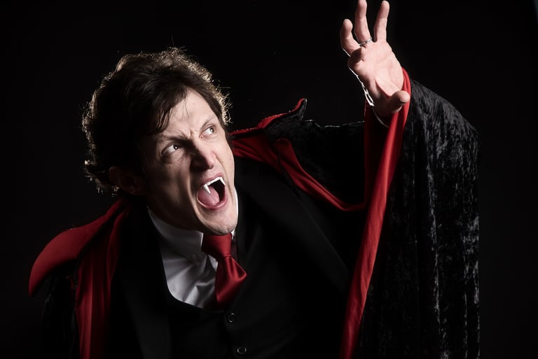 a man in a dracula costume with a red capelet looking like a vampire being scared of the sunlight
