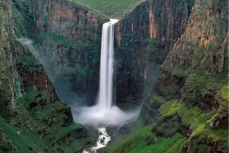 Maletsunyane Falls cascading down a steep rocky gorge into a misty pool in Lesotho.