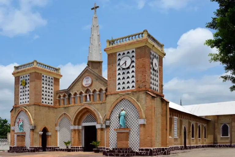 Historic brick architecture of the Sacre Couer cathedral in Brazzaville under a blue sky.
