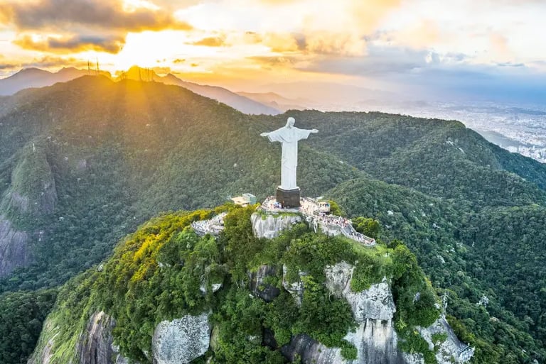 Aerial view of Christ the Redeemer statue atop Corcovado Mountain in Rio de Janeiro at sunset.