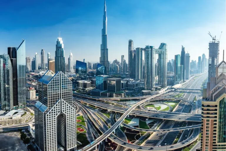 Panoramic view of the Dubai skyline featuring the Burj Khalifa and complex highway interchanges.