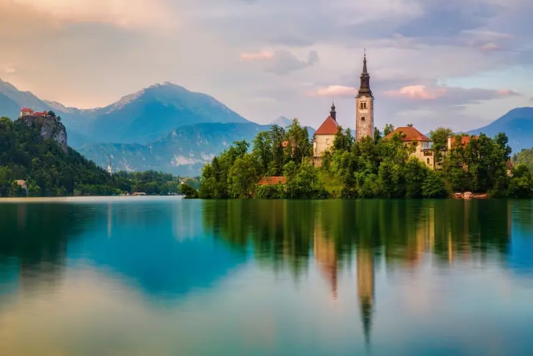 Scenic view of Lake Bled island with the Assumption of Mary Church and Julian Alps mountains in Slovenia.