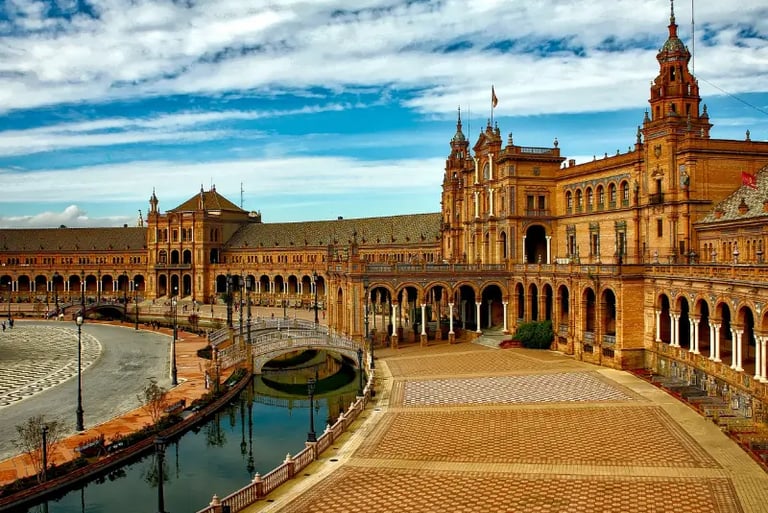 Panoramic view of the historic Plaza de España in Seville, Spain, featuring its ornate architecture and canal.