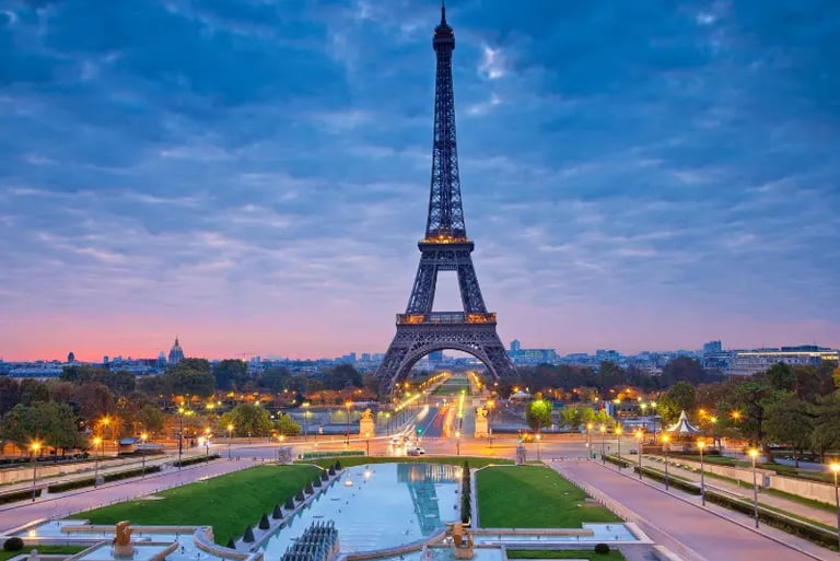 The Eiffel Tower at sunrise overlooking the Trocadéro gardens and fountains in Paris, France.
