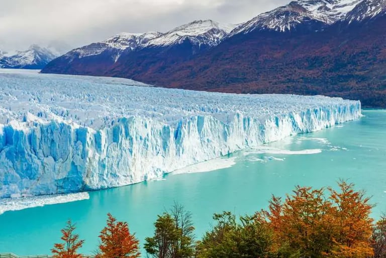 The massive Perito Moreno Glacier in Patagonia, Argentina, meeting turquoise water near snow-capped mountains.