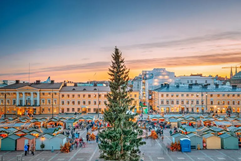 Festive Helsinki Christmas Market at Senate Square with a tall tree and sunset city views.