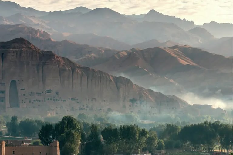 Misty morning view of the Bamiyan Valley mountains and ancient Buddha cliff niches in Afghanistan.