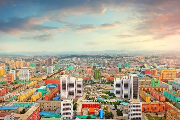 Aerial view of colorful residential apartment buildings in Pyongyang, North Korea at sunset.