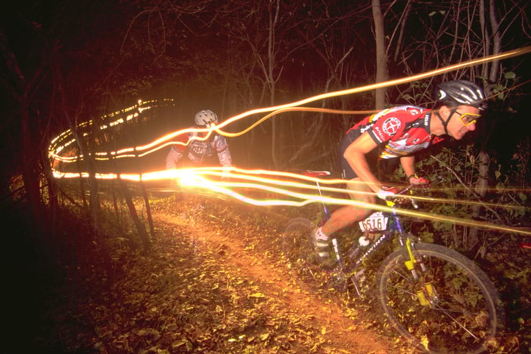 a man riding a bike at night on a trail