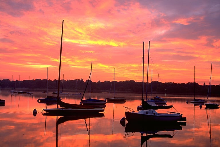 a sunset sky with boats and a sunset in the background