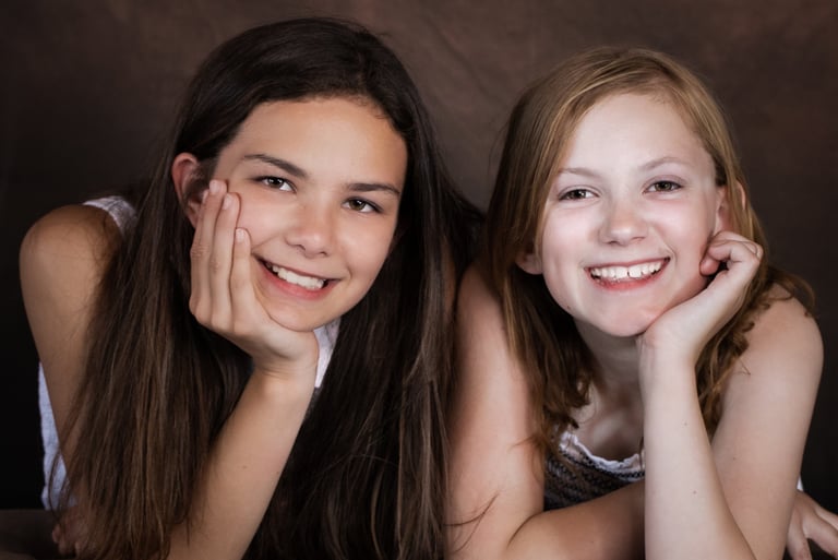 two girls are smiling and posing for a picture