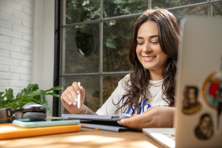 a woman sitting at a table with a pen and pencil