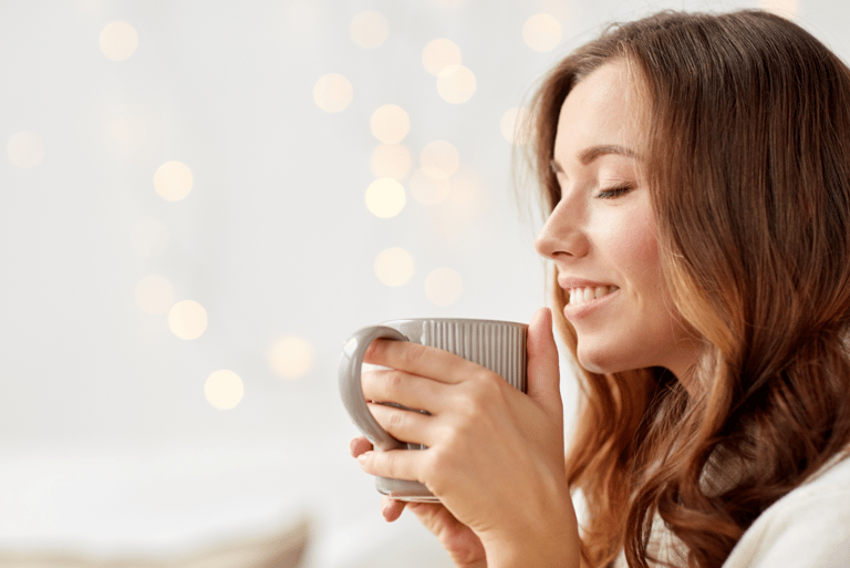 a woman is holding a cup of coffee