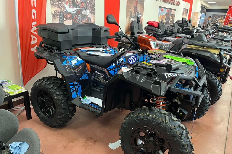 Custom blue and black Segway ATV with storage box displayed in a powersports showroom.