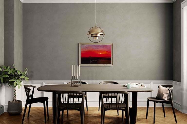 Modern dining room with a dark wood table, black chairs, gold pendant light, and sunset wall art.