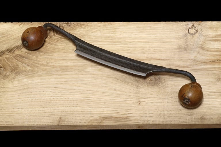 a draw knife and a knife on a wooden table