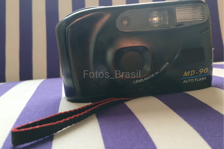 Sobre uma almofada está a majestosa, uma câmera fotográfica de filme do final dos anos 90