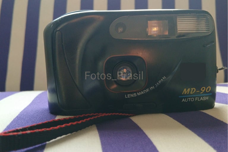 Sobre uma almofada está a majestosa, uma câmera fotográfica de filme do final dos anos 90