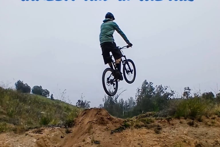 "Mountain biker stiff in the air with extended arms and legs