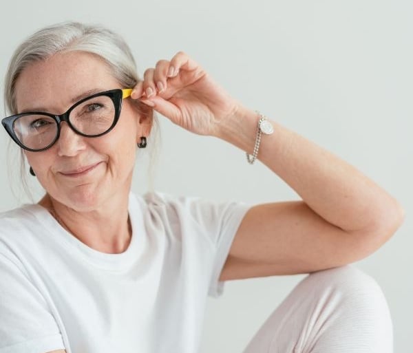a woman with glasses and a white shirt