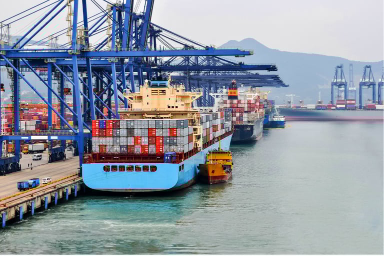 Container ship docking at sea port with cargo cranes and containers in background.