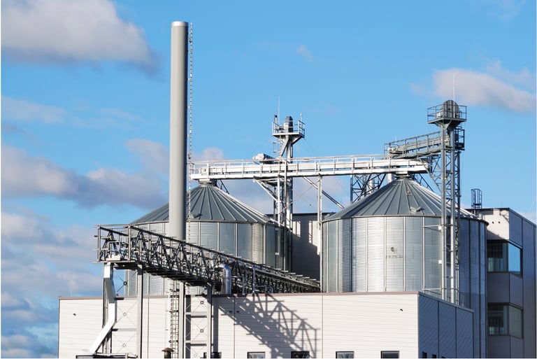 Industrial factory with silos and pipelines, illustrating perimeter monitoring and fire alarm integration for manufacturing