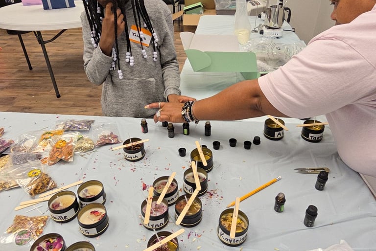 A child and adult instructor work together at a DIY candle making workshop with tins and essential oils.