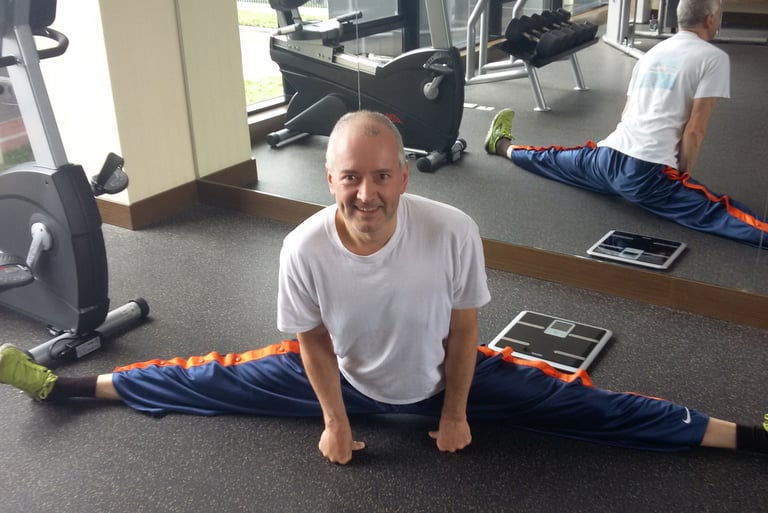 Jörg Grube im Fitnessraum eines Hotels im Spagat