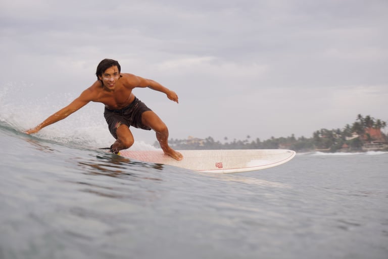 man riding surfboard looking into camera