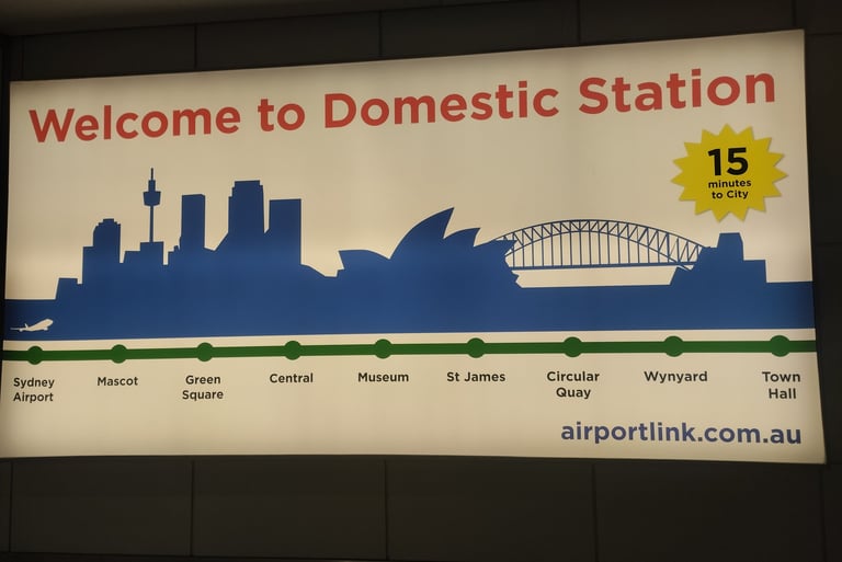 A bright sign at Sydney’s Domestic Station welcomes travelers, featuring a skyline illustration with iconic landmarks