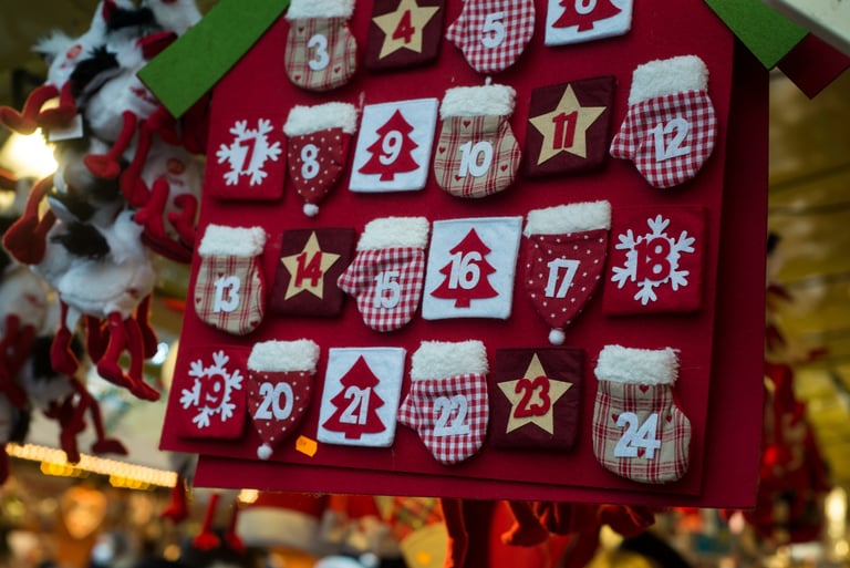 Red felt Christmas advent calendar featuring numbered pockets shaped like mittens, stars, and trees.