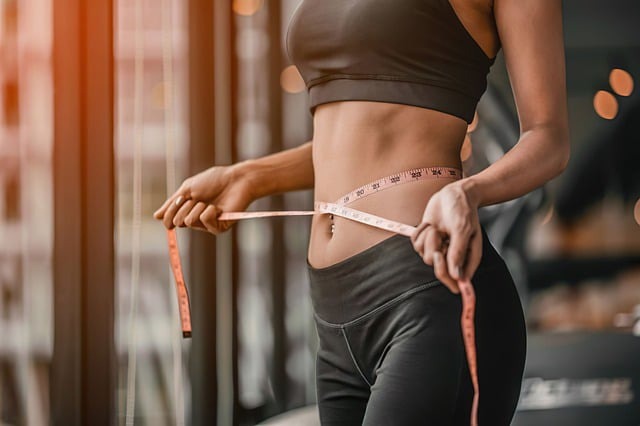 Fit dieter with tape measure around waist