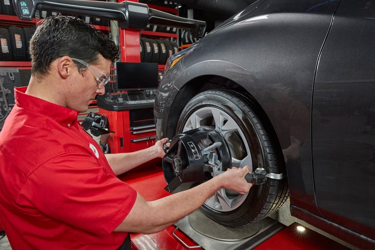 A Big O Tires employee changing a tire