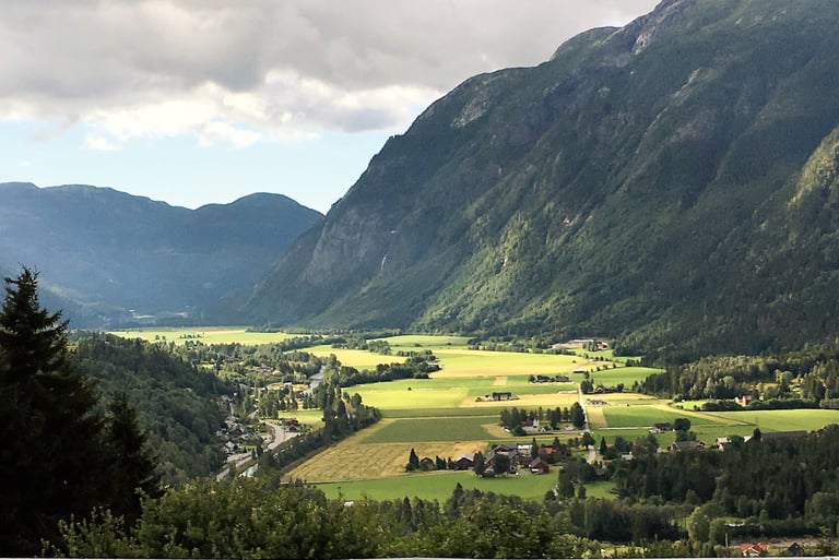 the sun shines on a valley with mountains in the distance