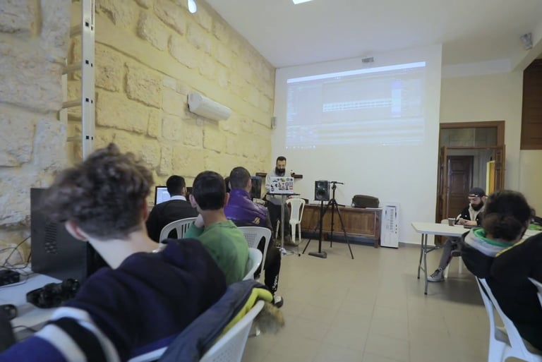 a group of people sitting at tables in a room attending a workshop on music production in lebanon