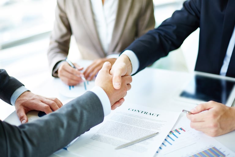 a group of people shaking hands over a table