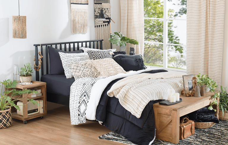 uma cama com uma cama preta e um banco de madeira