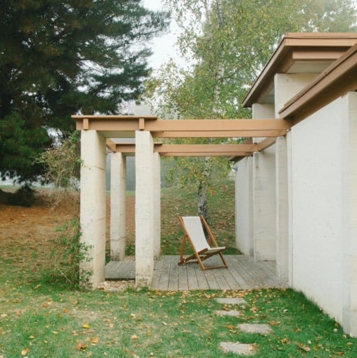 Simple, stamped concrete gazebo with a wooden chair
