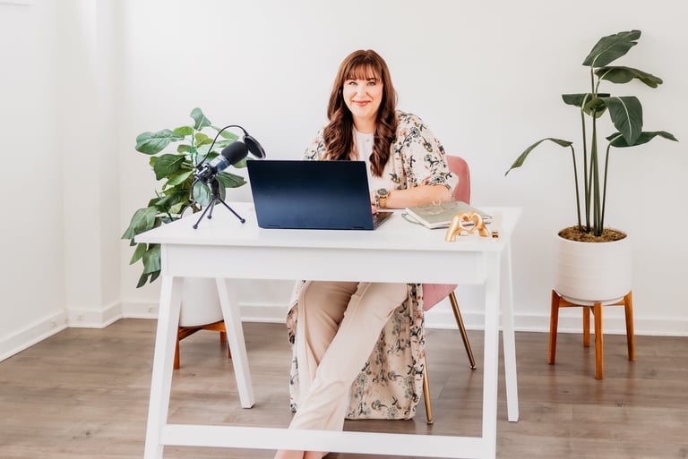 a woman sitting at a desk with a laptop computer