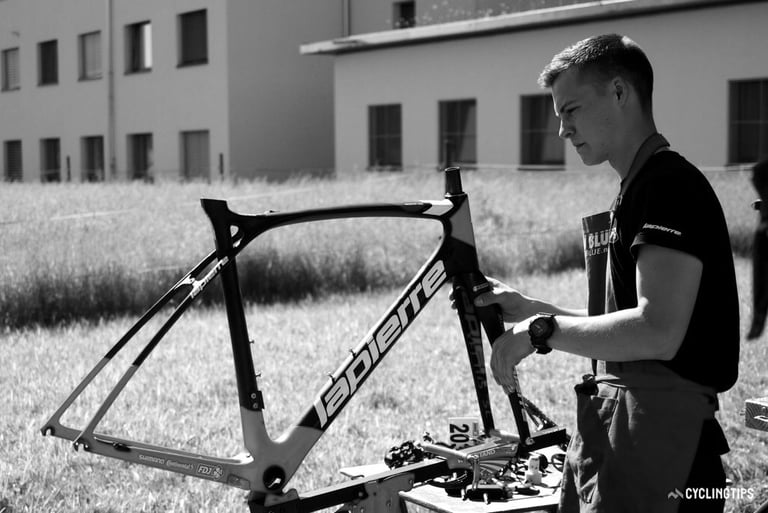 Karl Guillois officiant comme mécanicien sur un cadre de route du peloton professionnel World Tour