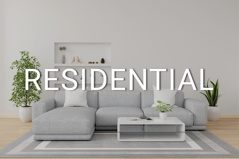 Modern residential living room interior featuring a grey sofa, minimalist decor, and potted plants.