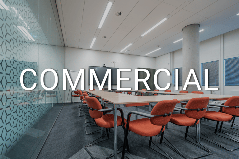 Modern commercial office conference room with orange chairs and a large wooden meeting table.